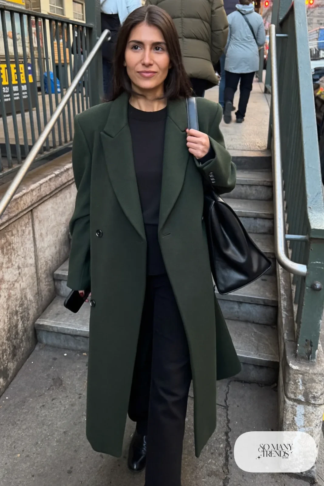 Woman in long forest green wool coat, black sweater, black straight pants and black leather boots, outfit 24