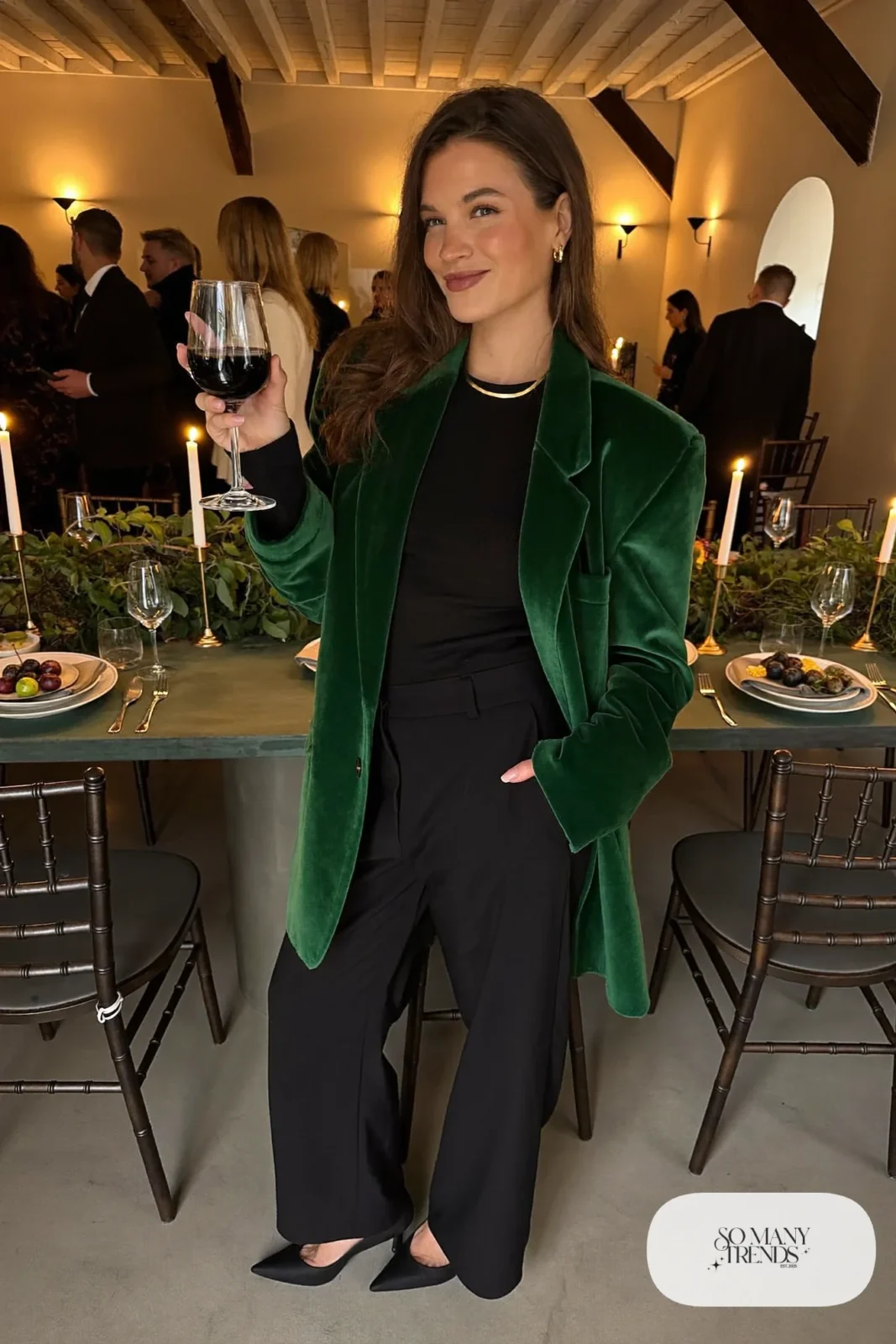 Woman in forest green velvet blazer, black top, black wide-leg pants, black pumps and gold jewelry, outfit 26