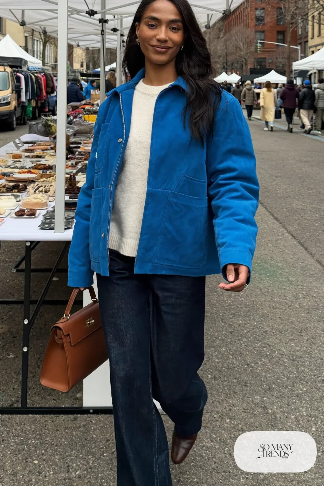 Woman in wide-leg indigo jeans, cobalt chore jacket, cream knit and brown boots, look 9