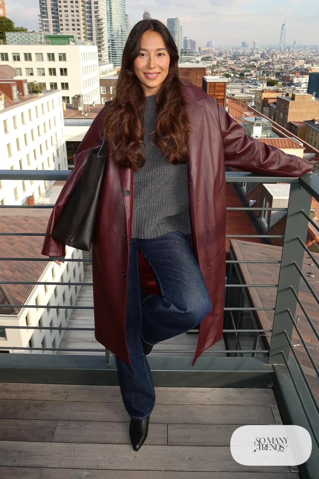 Woman in dark jeans, burgundy faux leather coat, gray knit and black boots, look 15
