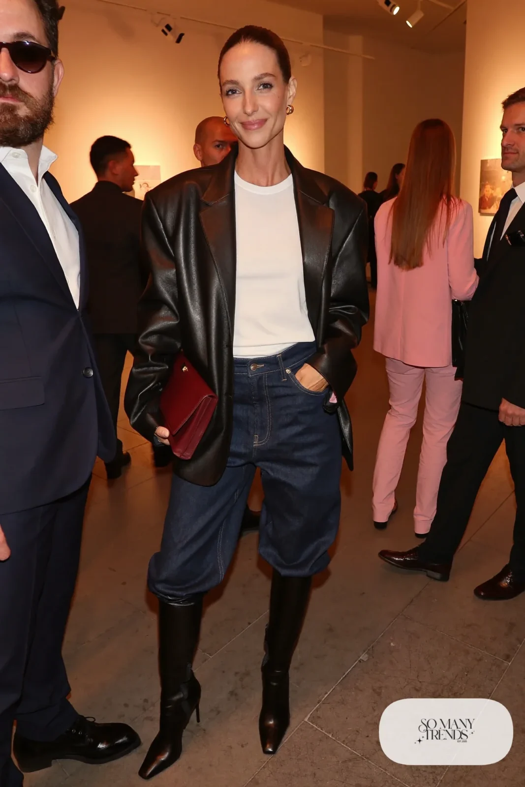 Woman in straight jeans tucked into black boots, black leather blazer and white tee, look 19