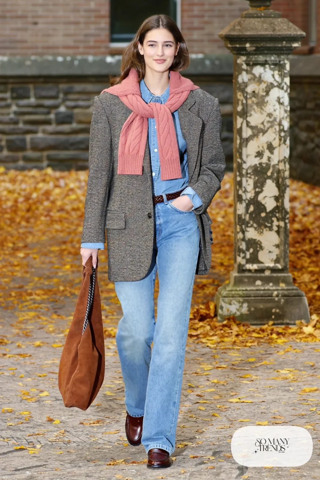 Woman in light blue straight jeans, denim shirt, herringbone blazer and red sweater tied on shoulders, look 21