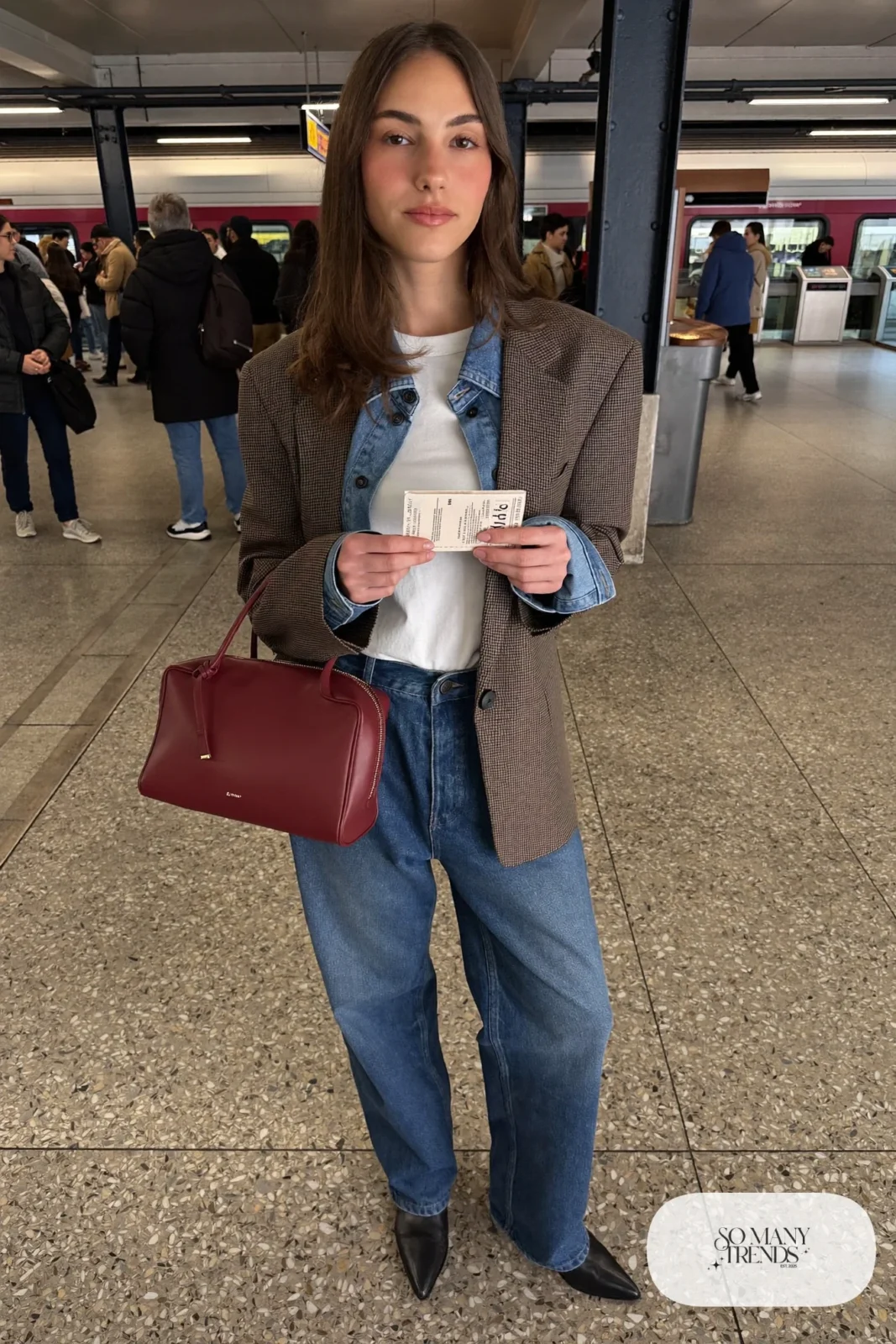 Woman in mid-blue straight jeans, open denim shirt, white tee, brown check blazer and burgundy bag, look 23