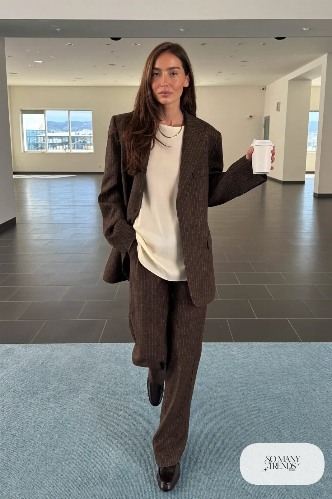 Woman in a relaxed mocha pinstripe blazer and wide-leg pants with a cream shell top and brown loafers, outfit 1