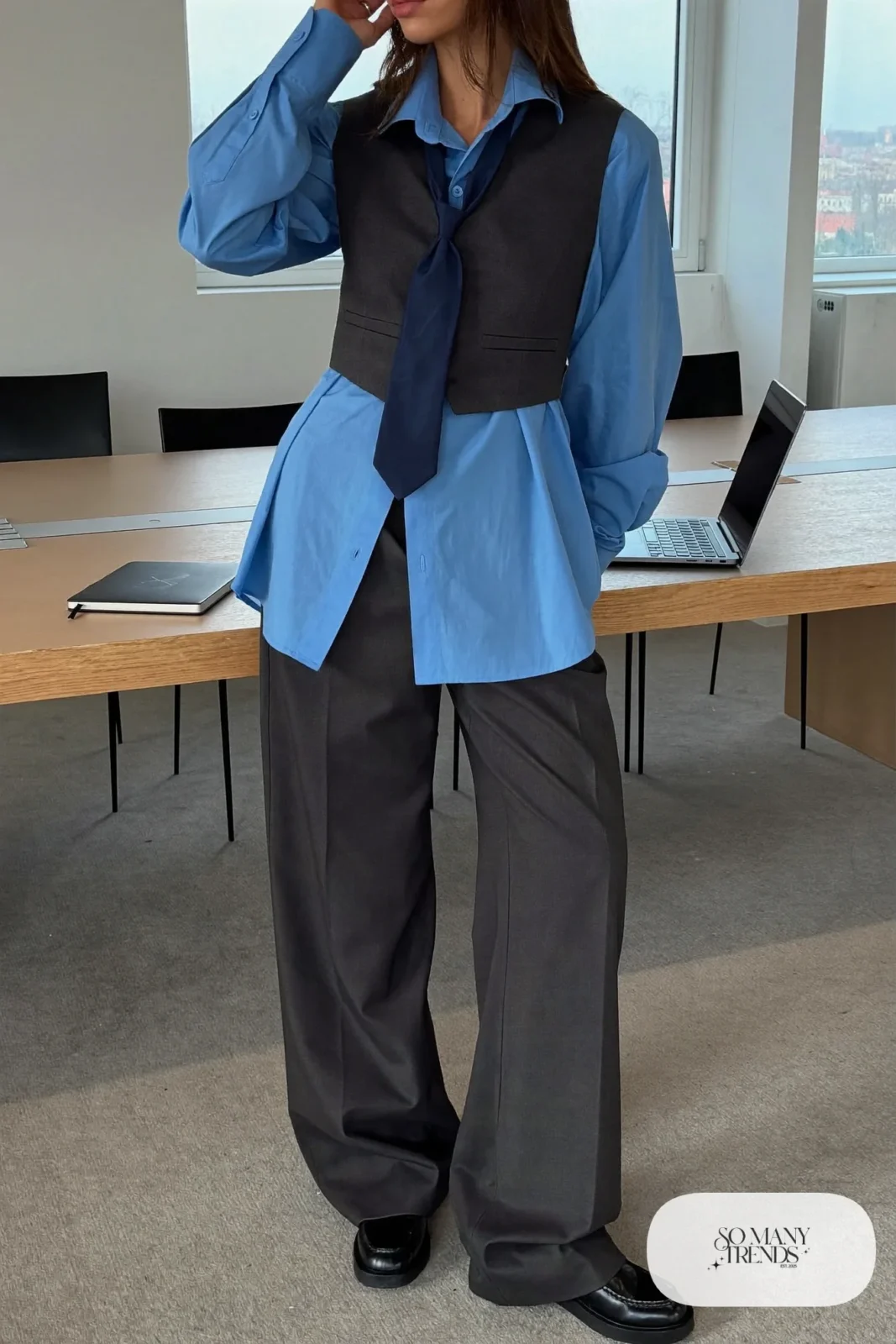 Woman in a sky blue shirt with a slim dark tie, charcoal vest, wide-leg gray pants and black loafers, outfit 2