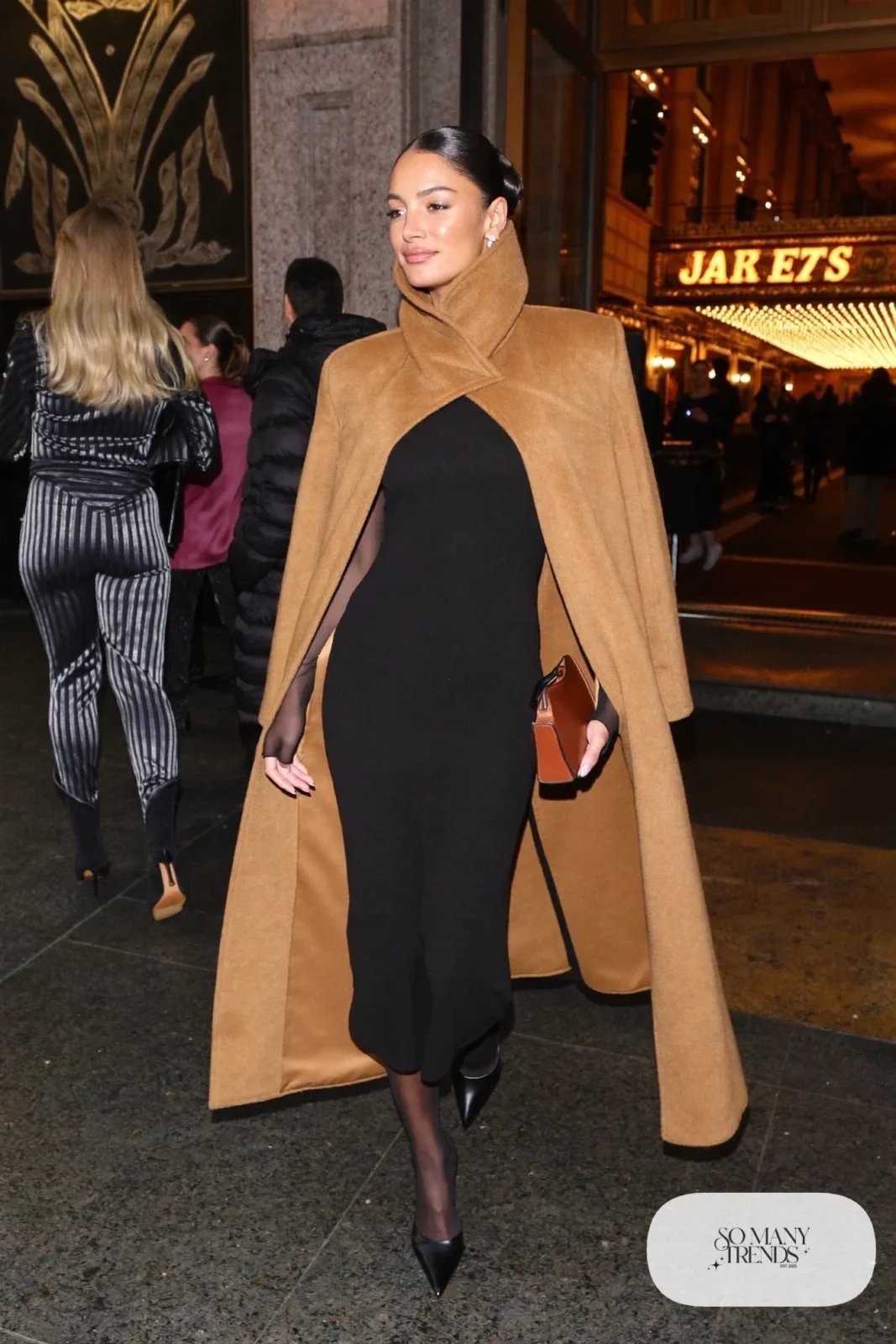 Camel wool cape coat over black knit column dress with sheer tights and black kitten-heel pumps, outfit 10