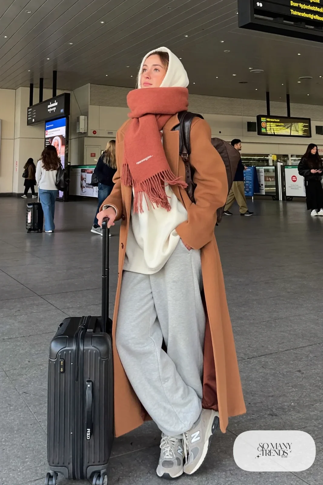 Woman in long camel coat, cream hoodie, gray sweatpants and gray New Balance 9060 sneakers, outfit 23