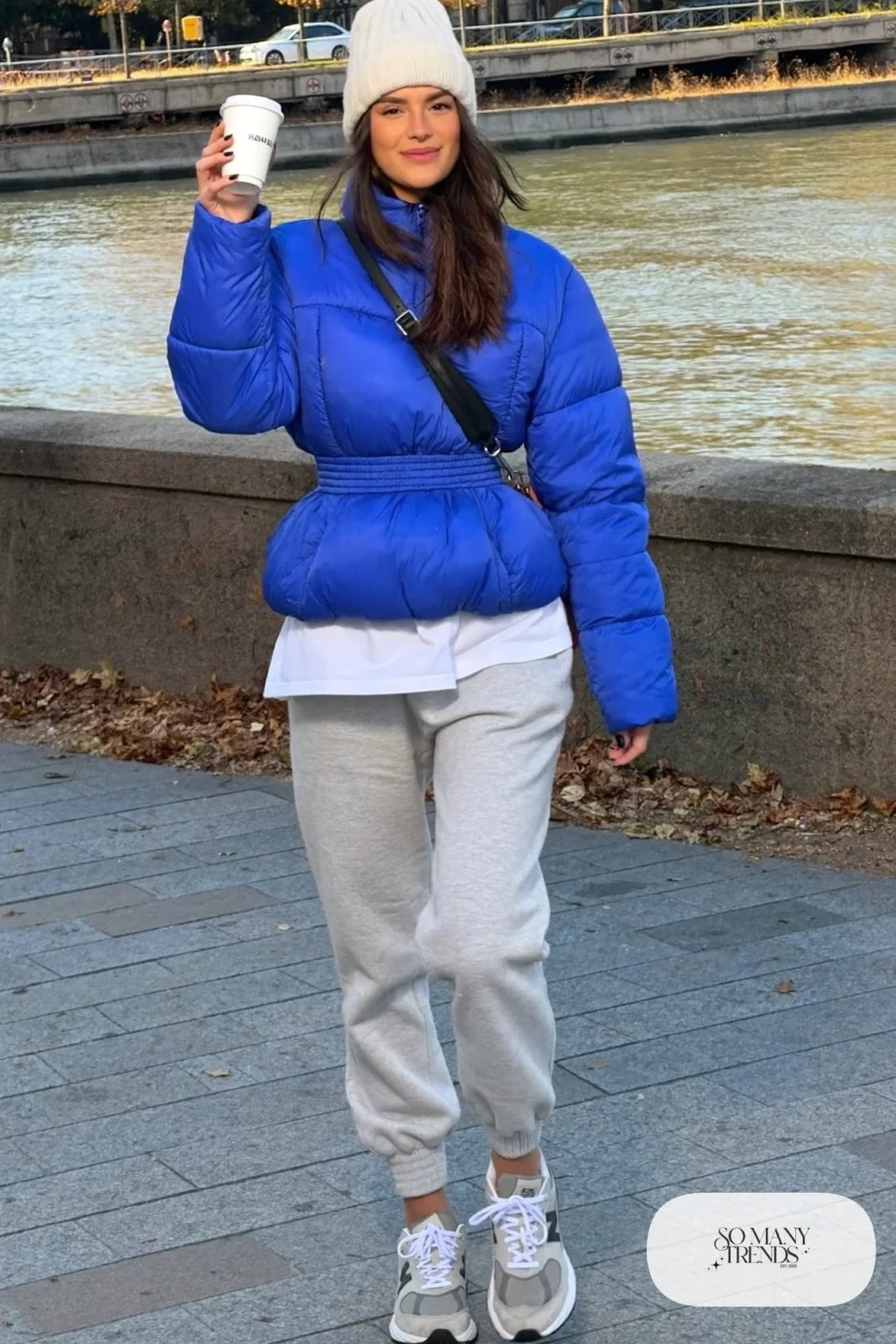 Woman in cobalt quilted jacket, cream beanie, gray joggers and gray New Balance 9060 sneakers, outfit 25