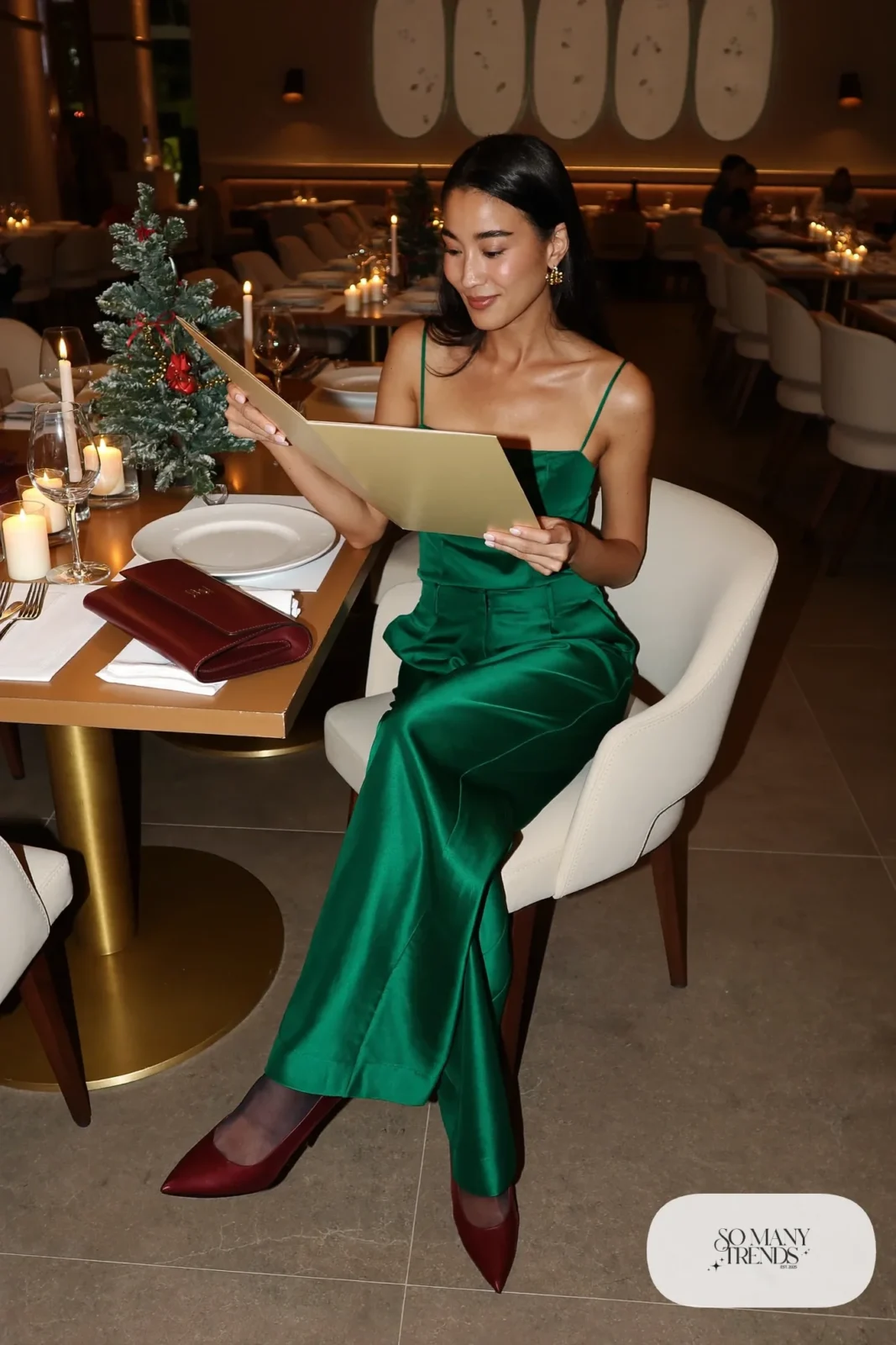 Woman in emerald satin camisole and wide-leg pants set with wine heels and clutch, outfit 11