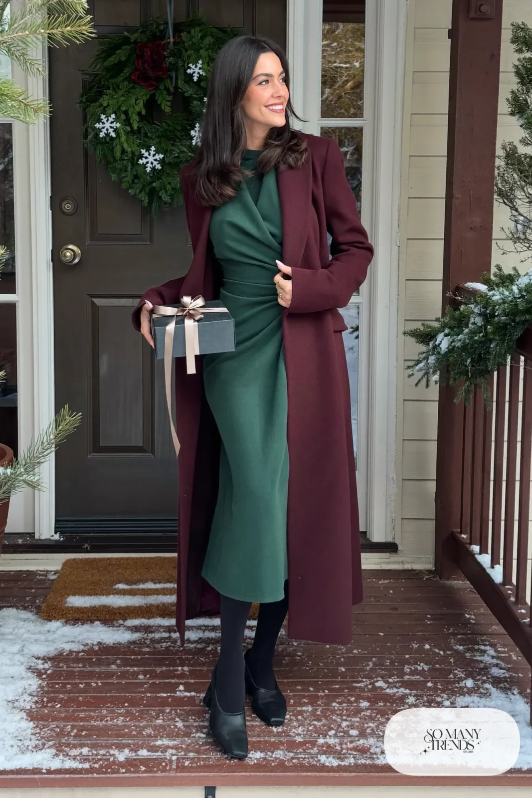 Woman in forest green wrap midi dress, long burgundy coat, opaque tights and low block-heel pumps, outfit 13