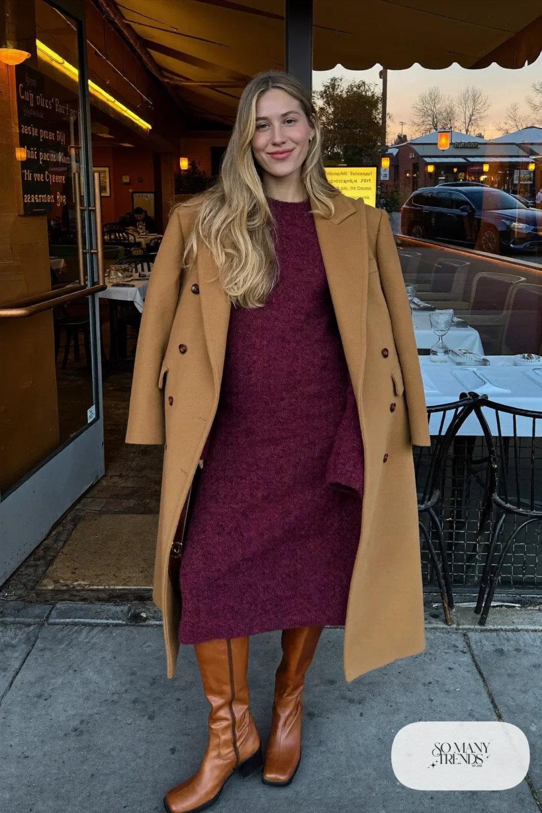 Woman in burgundy knit midi dress, long camel coat and brown leather knee boots, outfit 15