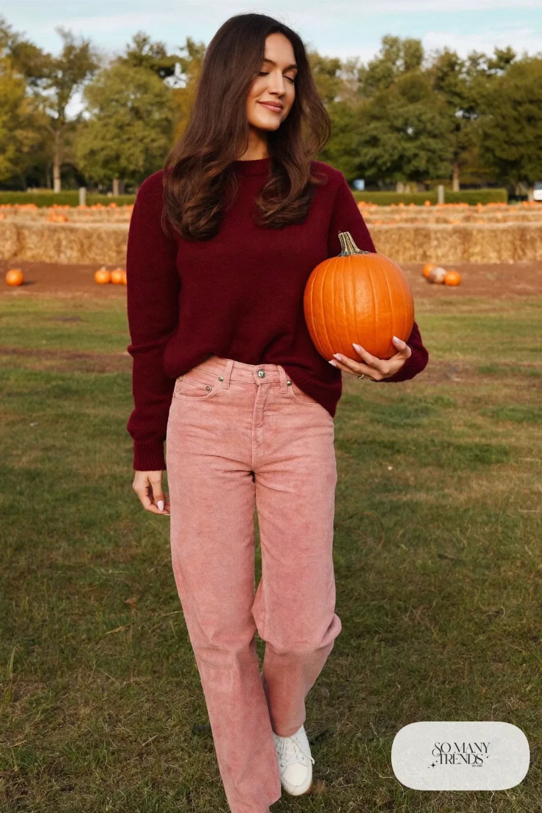 Woman in burgundy crewneck sweater, rose pink corduroy straight pants and white leather sneakers, outfit 23