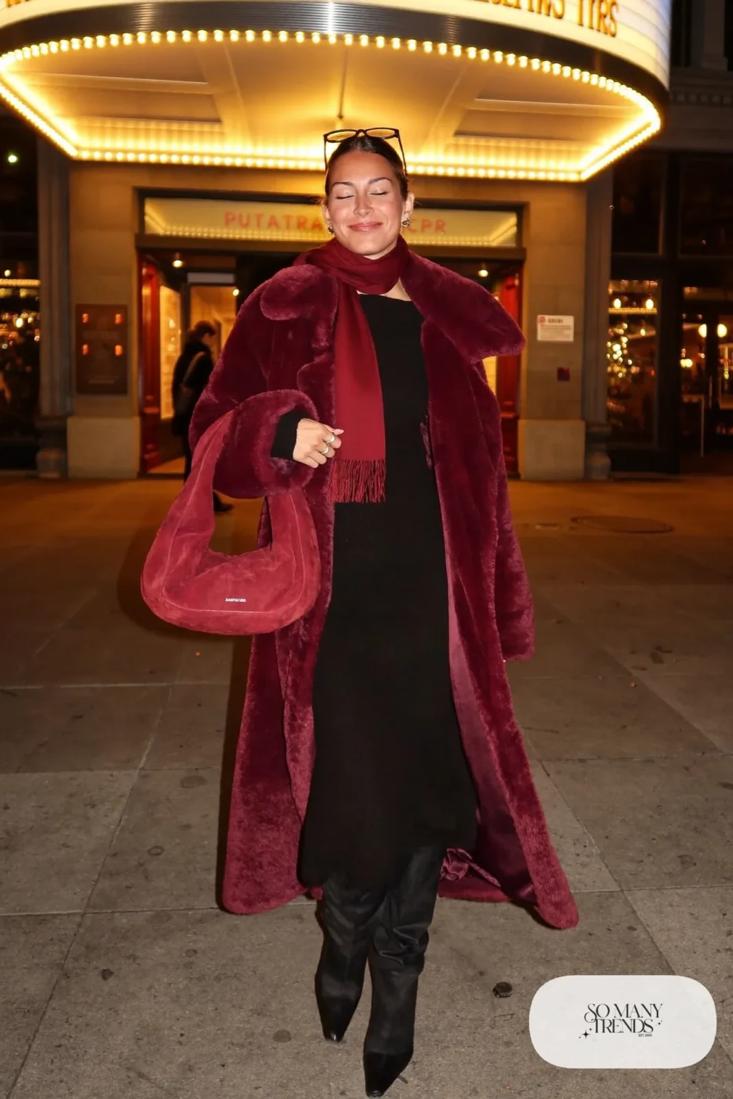 Woman in a burgundy teddy coat, matching scarf, black dress, black boots and burgundy suede bag, outfit 22