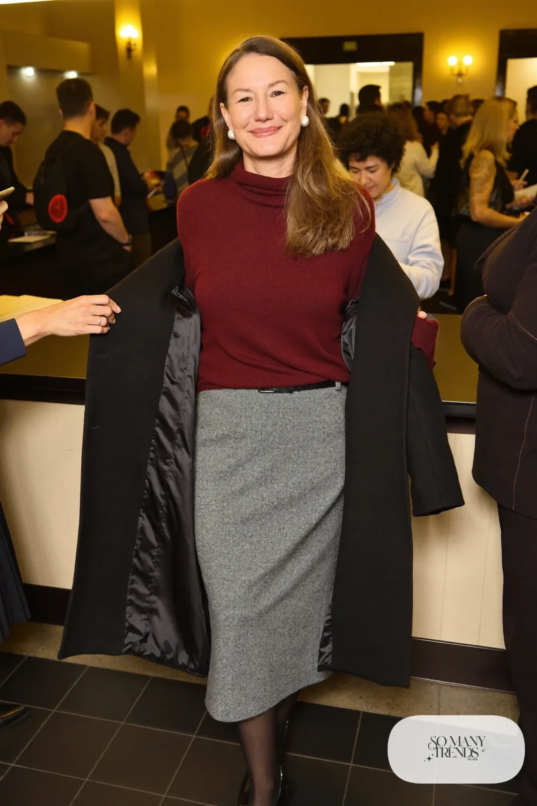 Woman in a burgundy fine knit sweater tucked into a gray wool midi pencil skirt with thin belt, sheer tights and black pumps, theater outfit 7
