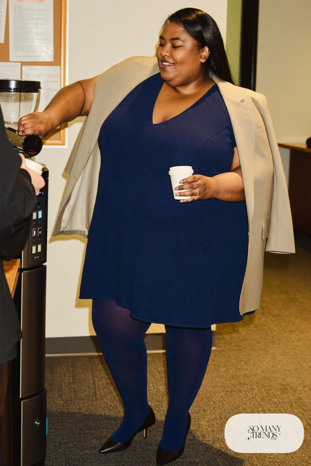 Woman in navy ponte V-neck midi dress, long oatmeal blazer, navy tights and black pumps, outfit 12