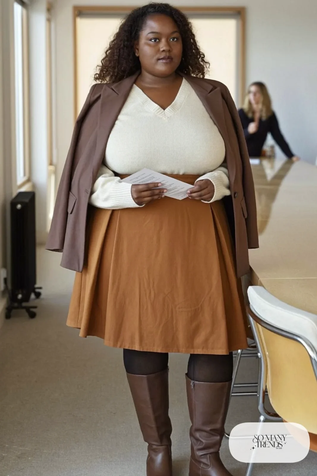 Woman in cream V-neck sweater, rust crepe A-line midi skirt, long espresso blazer and tall brown boots, outfit 19