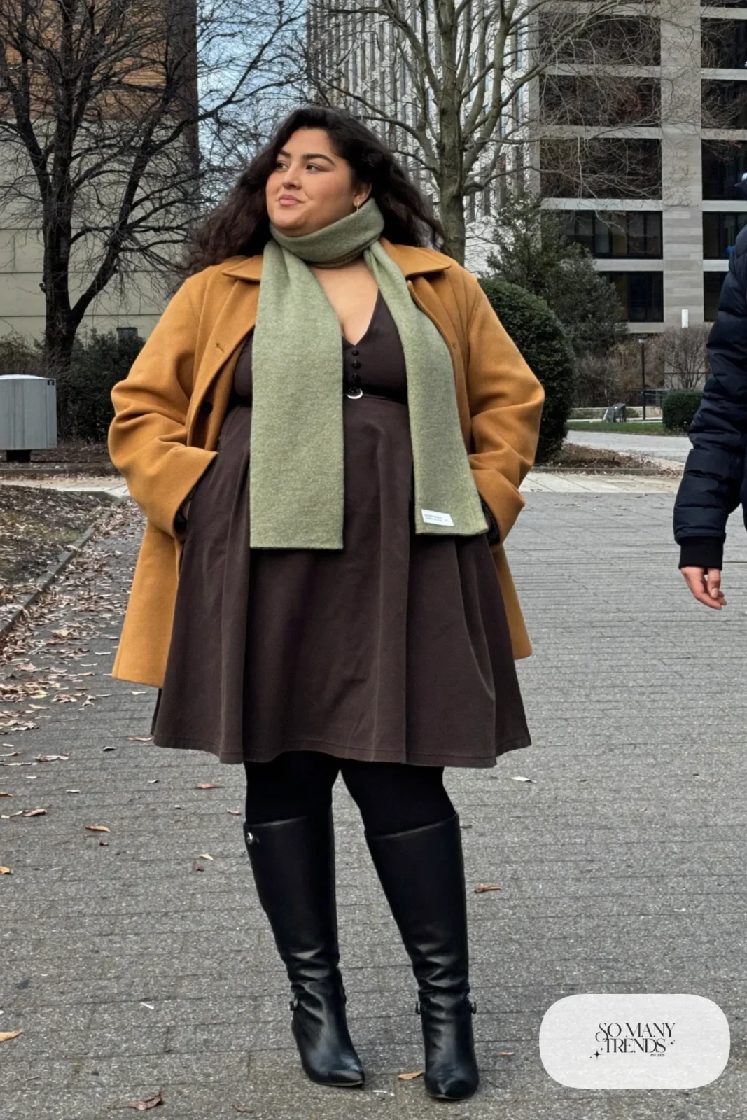 Woman in espresso ponte V-neck midi dress with belt, long sage scarf and tall black boots, outfit 21