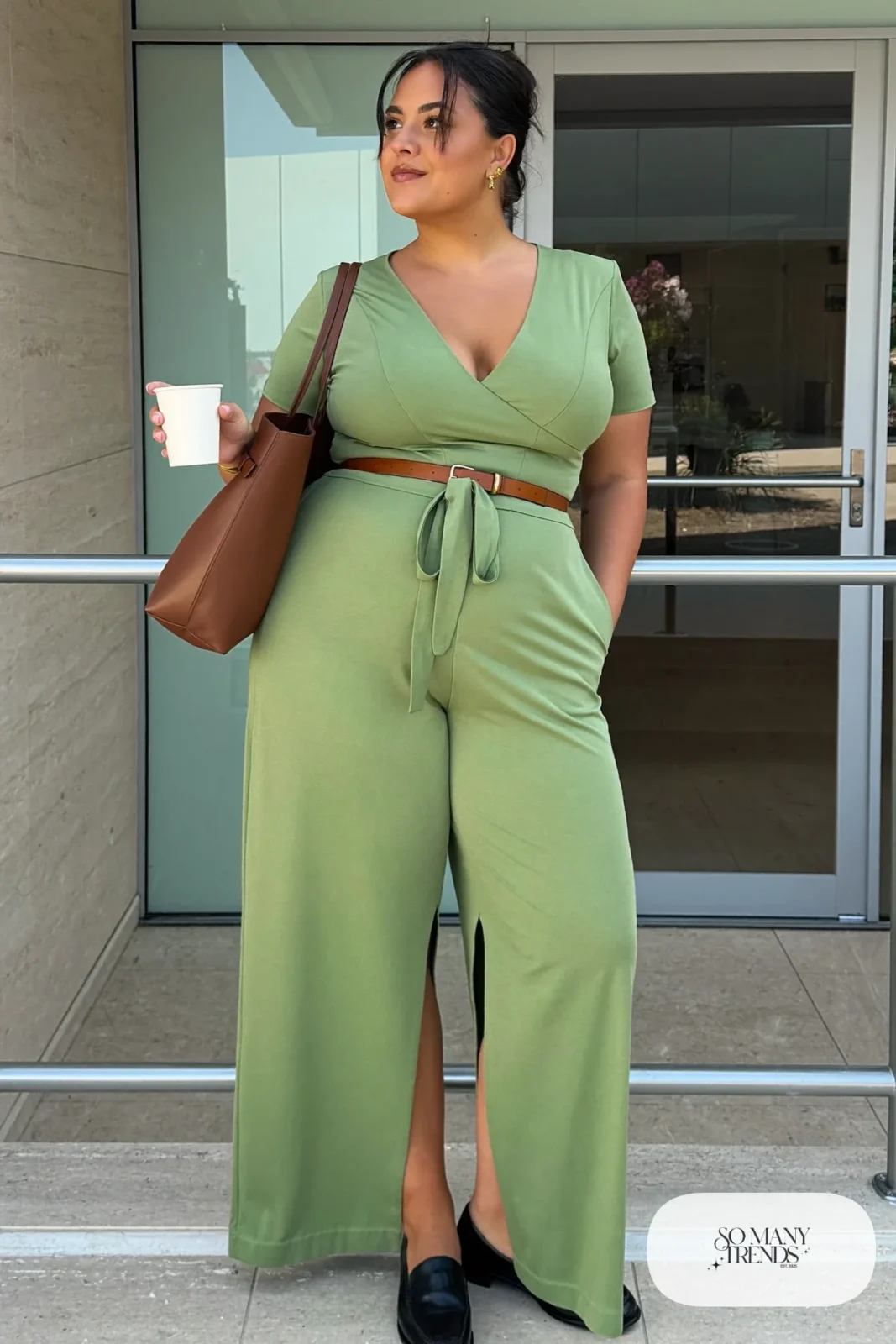 Woman in a sage green surplice wide-leg jumpsuit with a cognac belt and loafers, outfit 11