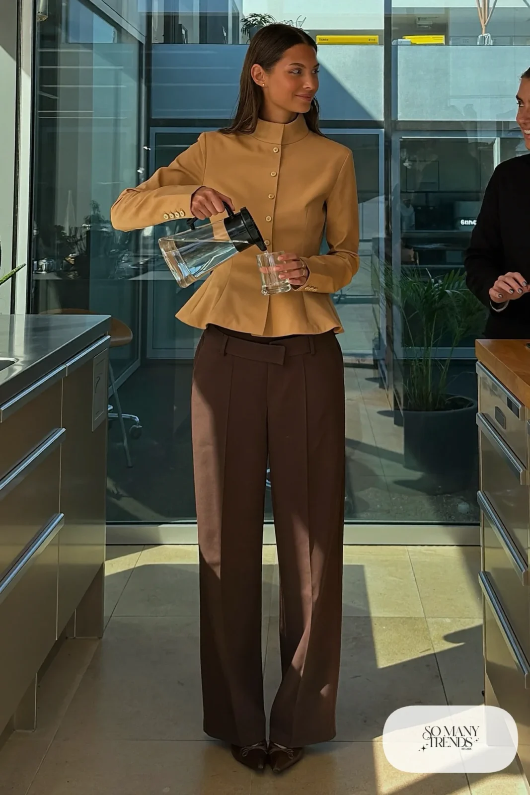 Woman with a straight athletic figure in a sand peplum blouse, high-waisted brown wide-leg pants and pointed pumps in an office, outfit 2