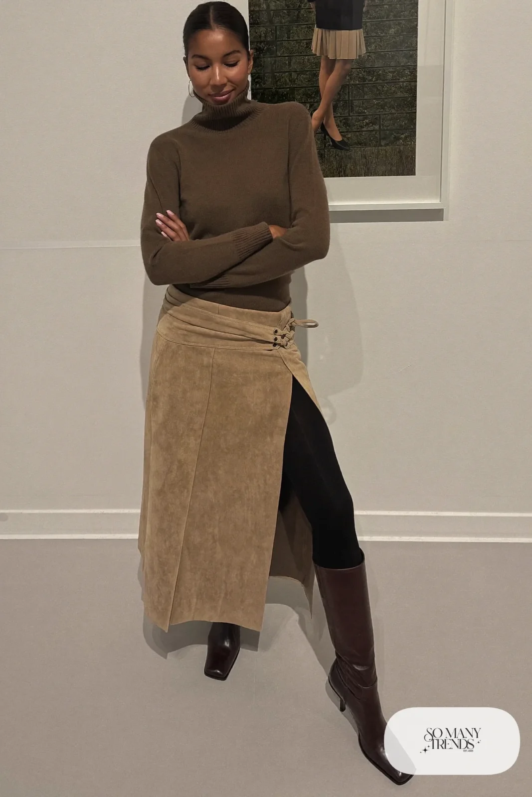 Woman with a straight athletic figure in a chocolate fitted turtleneck tucked into a sand wrap midi skirt with tall boots, outfit 12