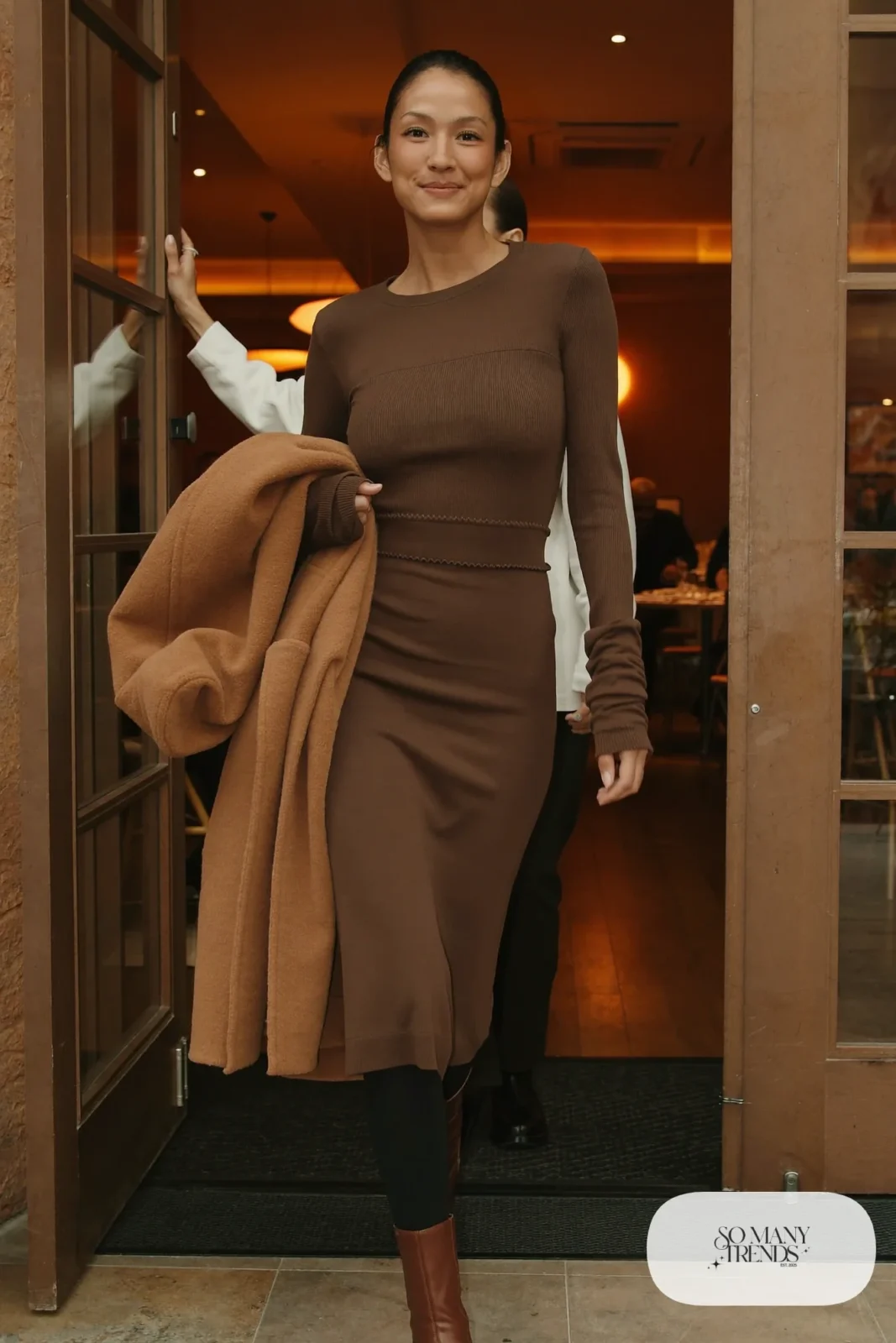 Woman with a straight athletic figure in a chocolate knit two-piece set with waist seam, a camel coat and brown boots, outfit 19