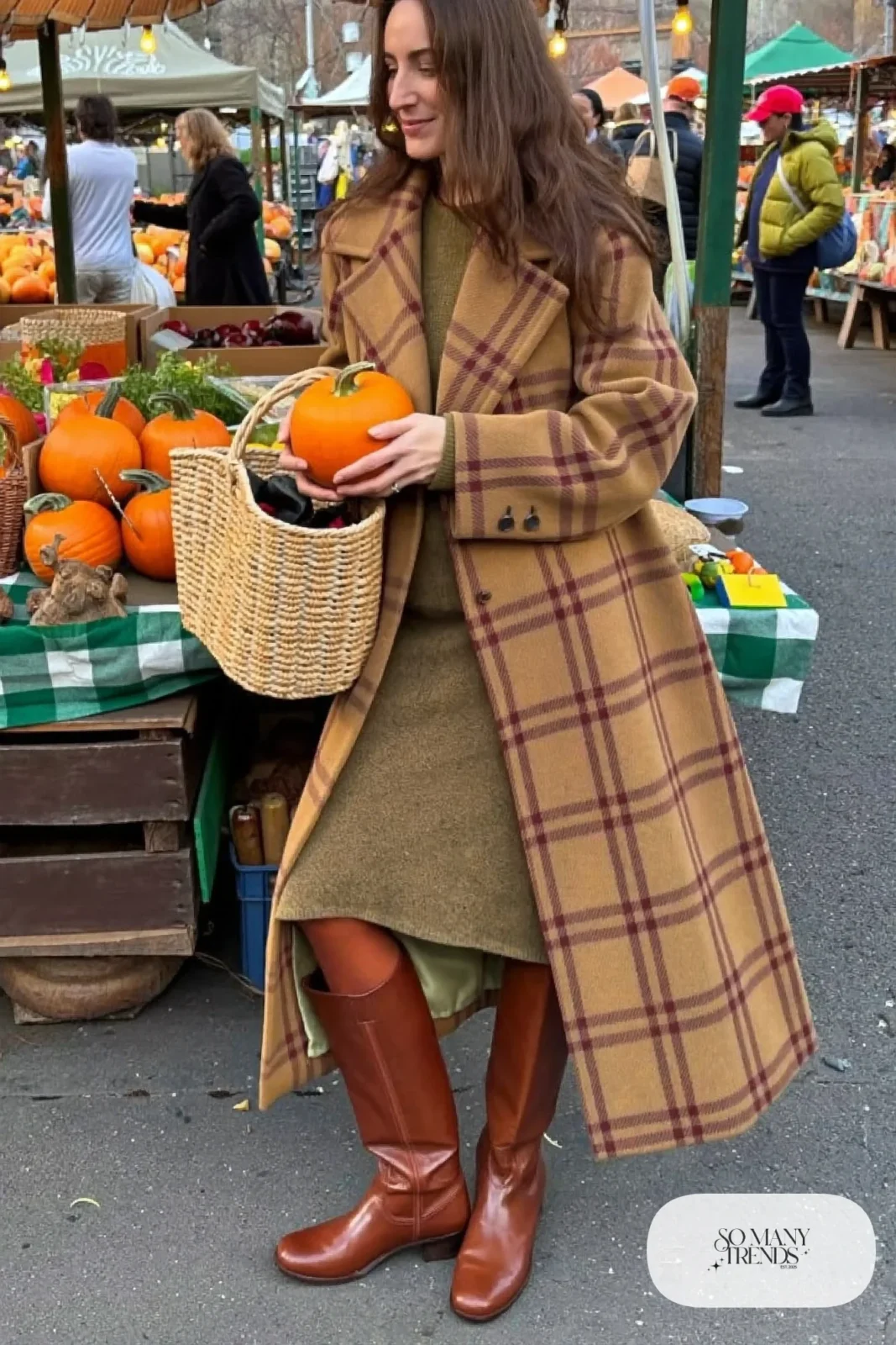 Woman in a camel plaid wool coat over an olive knit midi dress, brown tights and tall brown boots, outfit 26