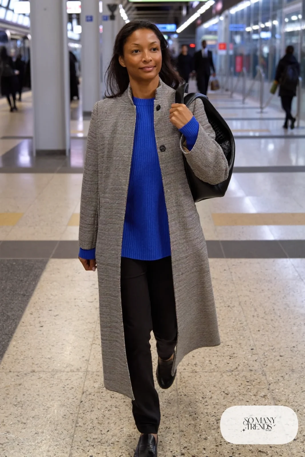 Woman in a gray houndstooth wool coat, cobalt blue sweater, slim black pants and black loafers, outfit 27