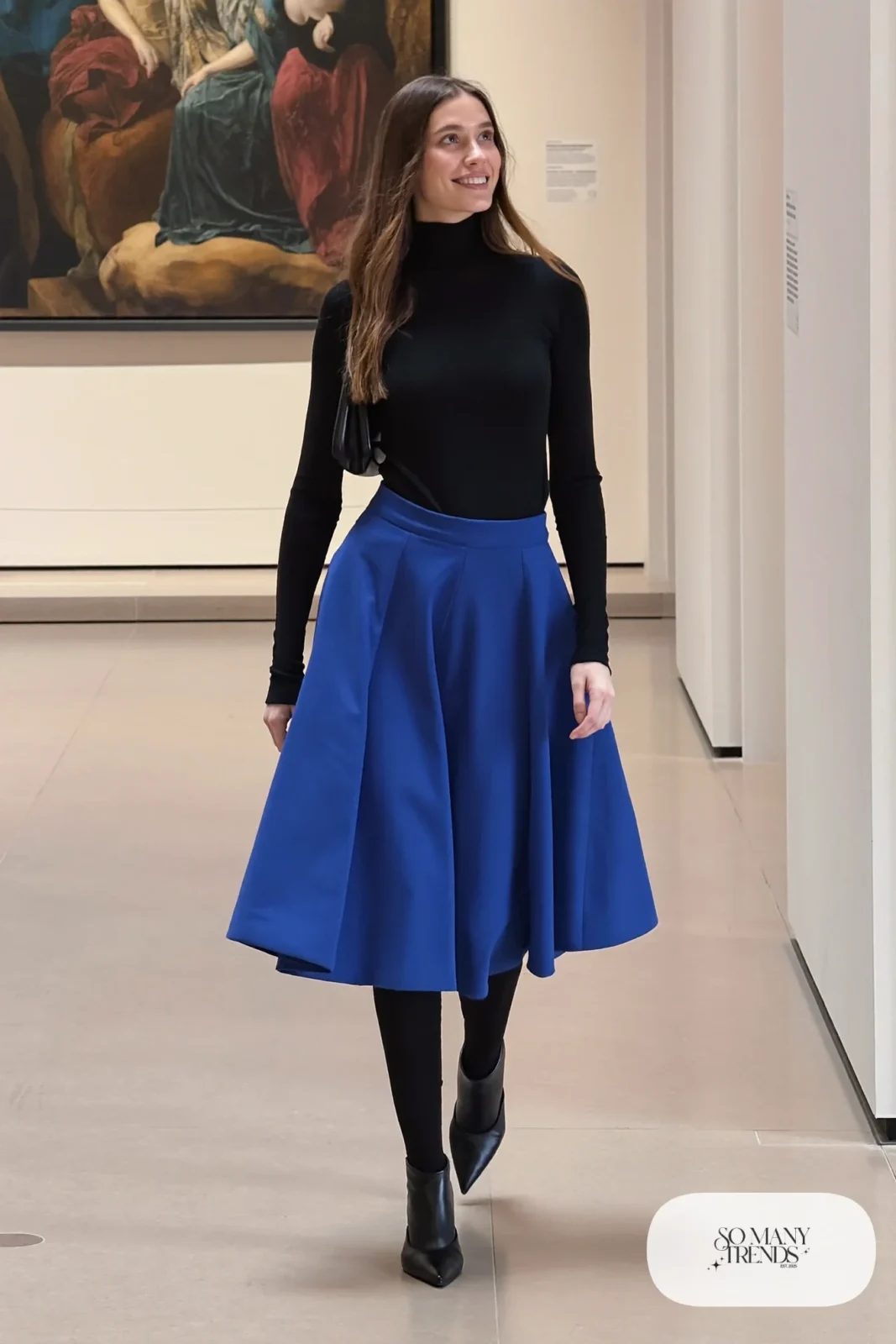 Woman with pear-shaped figure in a black turtleneck, cobalt A-line midi skirt, black tights and pointed boots, outfit 26
