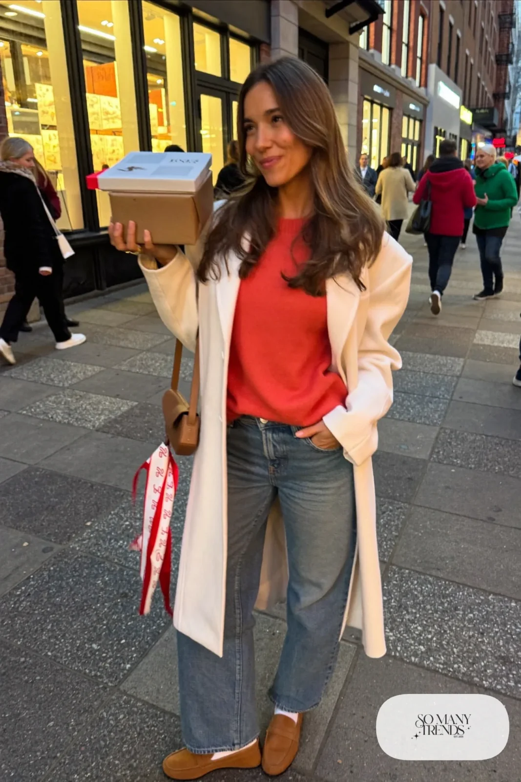 Woman in cherry red knit sweater, mid-wash straight jeans, white wool coat and tan loafers, outfit 12