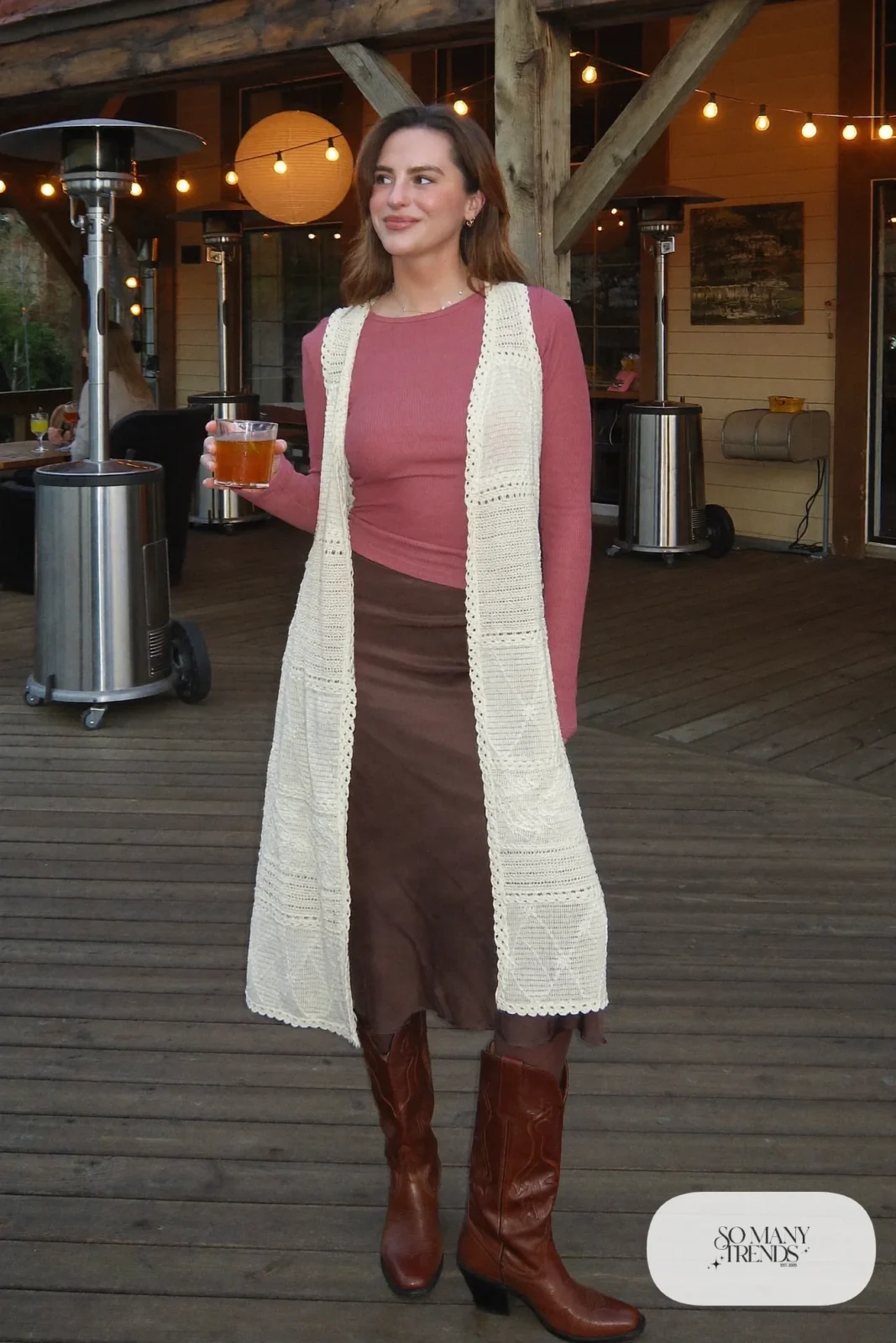 Cream crochet vest over fitted rose top with chocolate satin midi skirt, black tights and brown boots, outfit 19