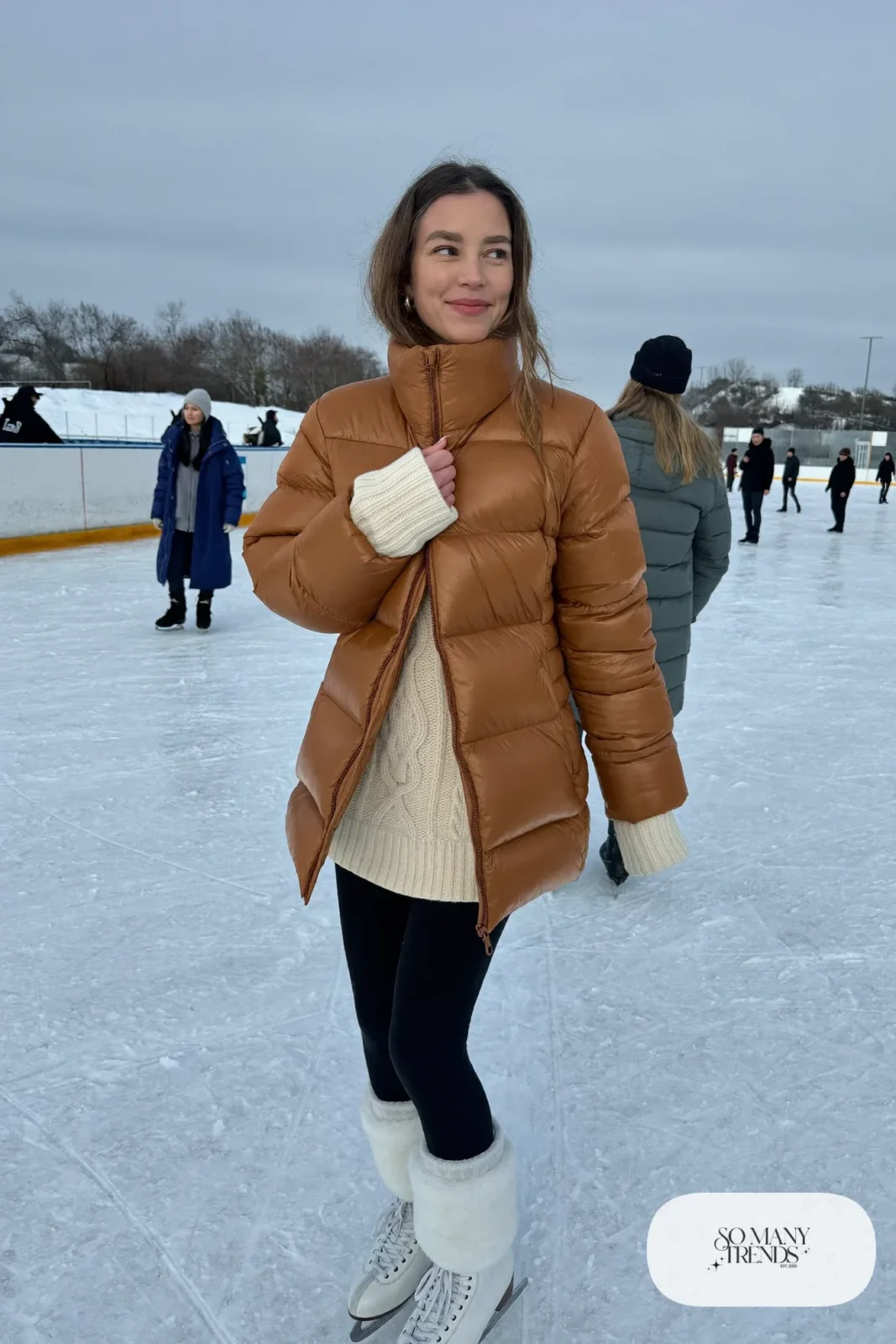 Mocha hip-length puffer coat over a cream cable-knit sweater, black fleece-lined leggings and white ice skates - outfit 1