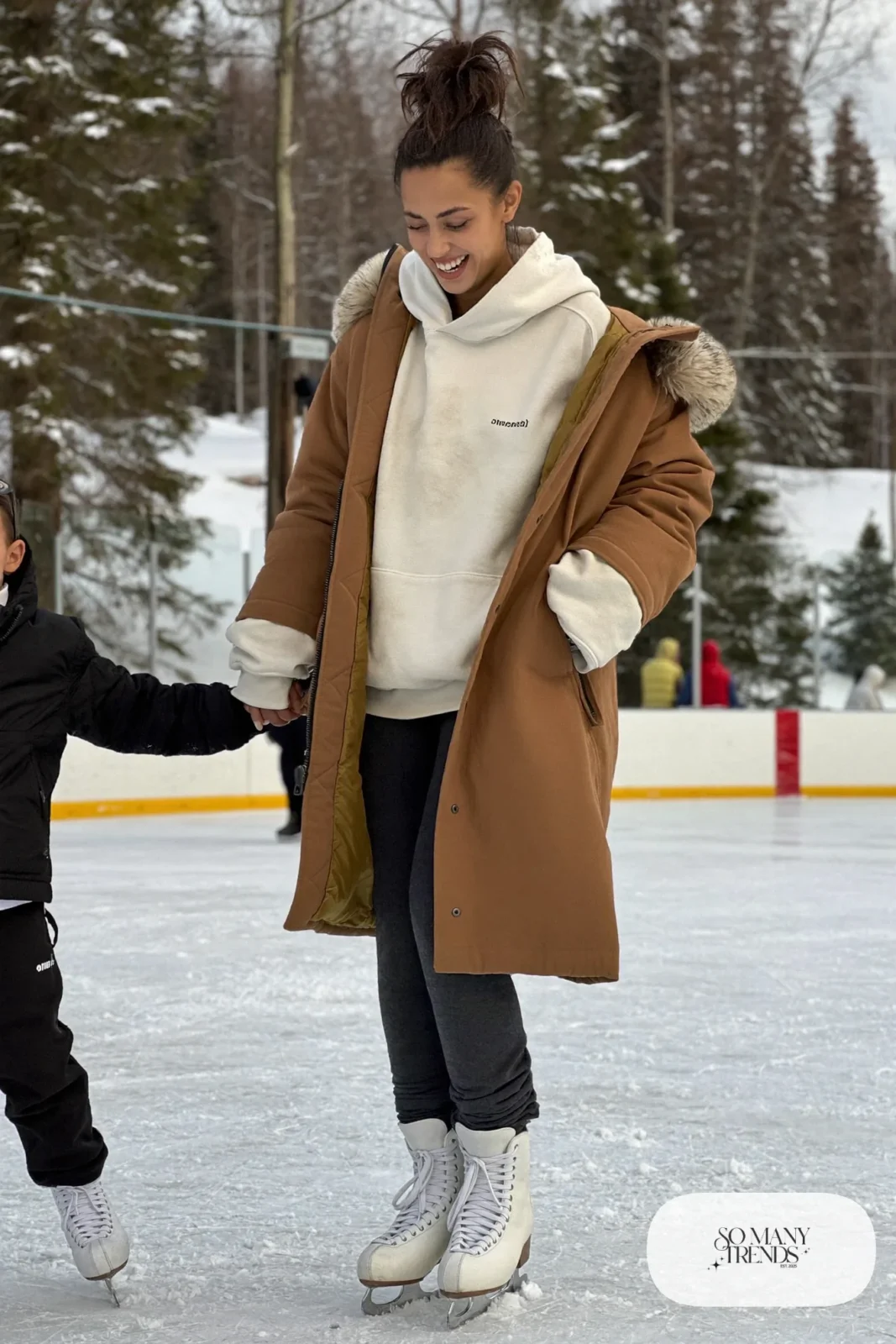 Oversized cream hoodie under mocha thigh-length parka, charcoal stretch joggers and ice skates - outfit 10