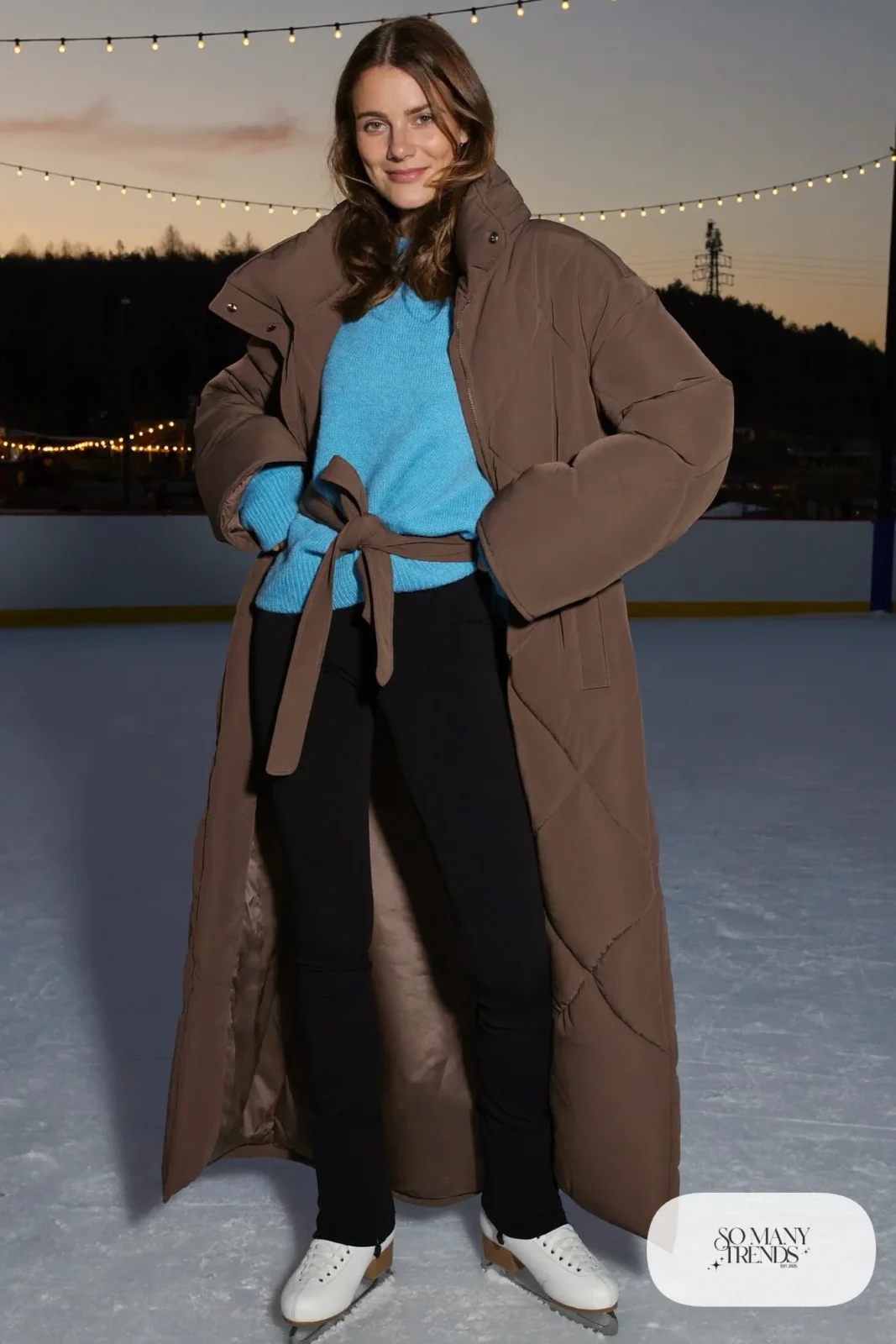 Mocha quilted belted trench coat over sky blue knit sweater, black stretch pants, cream beanie and ice skates - outfit 27