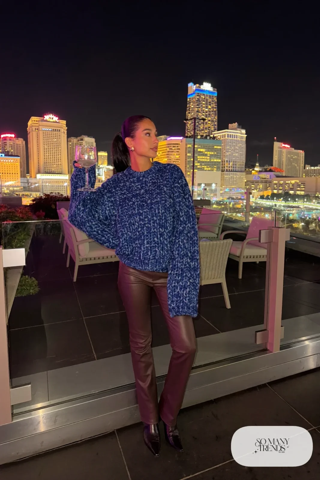Woman in chocolate leather pants, ink blue chunky sweater and black boots, NFR outfit 10