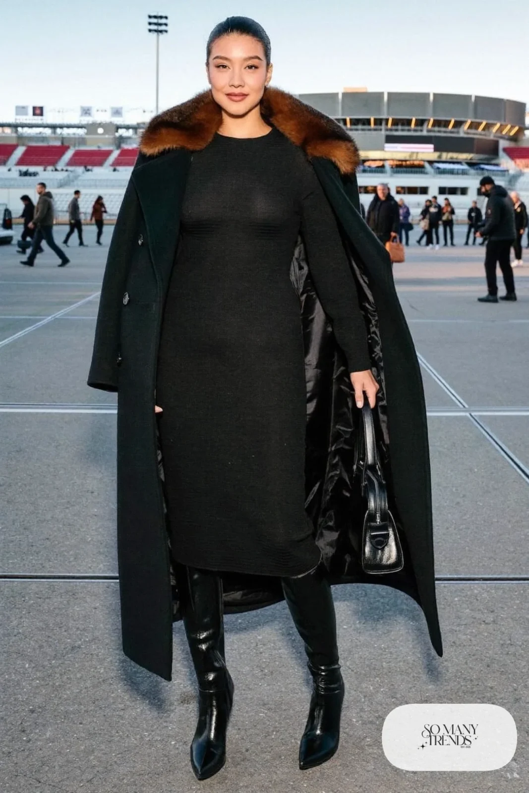 Woman in a black coat with espresso faux fur collar, black knit dress and tall boots, basketball game outfit 21