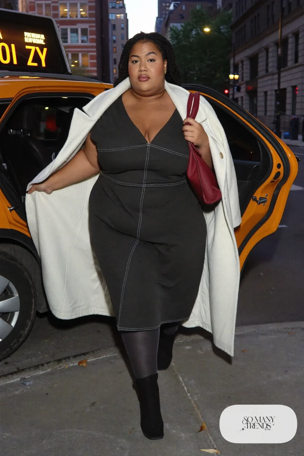 Plus size woman in black ponte midi dress with ivory cape coat and oxblood bag, outfit 4
