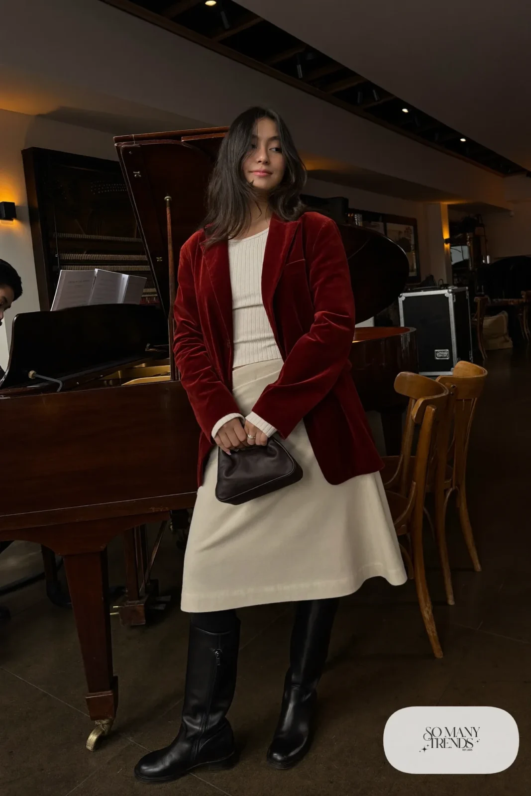 Plus size woman in oxblood velvet blazer, ivory knit top, navy A-line skirt and black boots, outfit 8