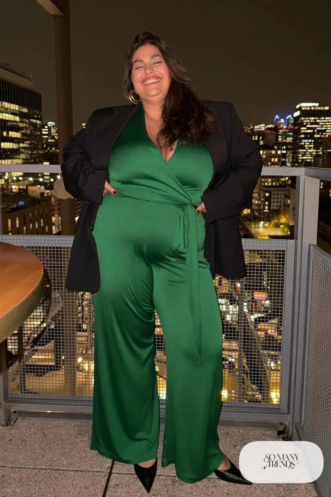 Plus size woman in emerald wide-leg jumpsuit with black blazer and black pumps, outfit 9