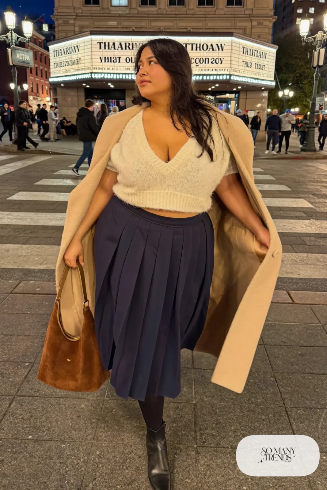 Plus size woman in navy pleated midi skirt, ivory sweater, beige cape coat and black ankle boots, outfit 21