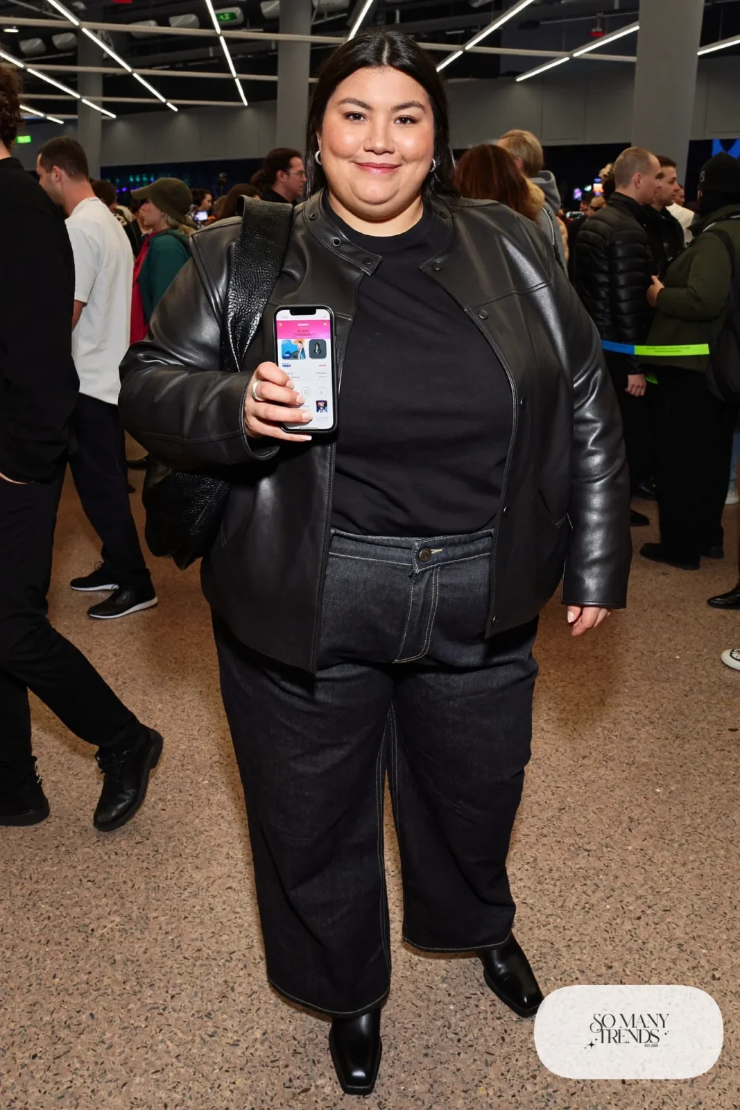 Plus size woman in black leather jacket, dark tee, wide jeans, crossbody bag and black boots, outfit 29