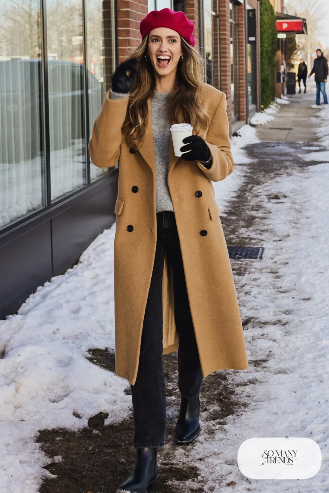 Woman in a camel double-breasted coat, wine beret, gray sweater, dark jeans and black boots on a snowy street, outfit 3