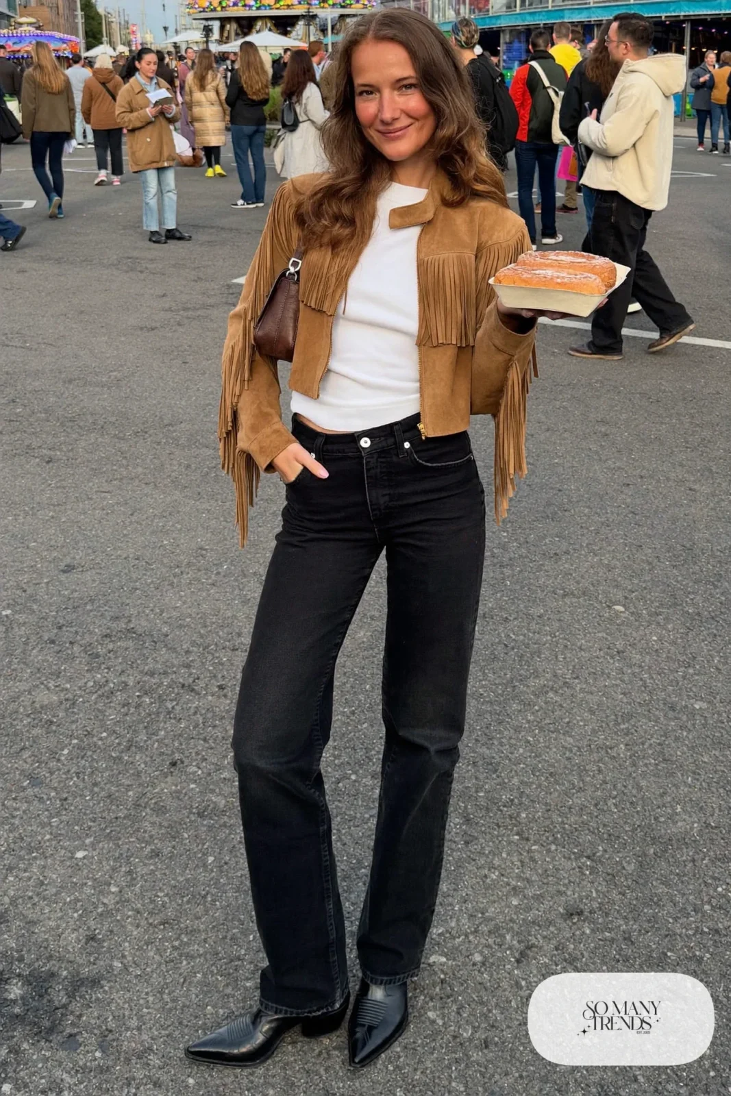 Woman in a tan suede fringe jacket, white tee, black straight jeans and black boots, outfit 2