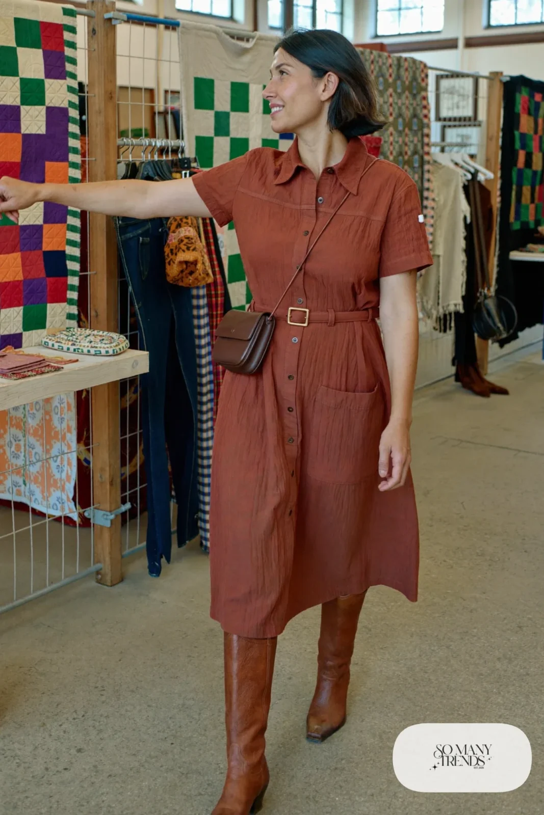 Woman in rust button-front cotton midi dress with tan boots and denim jacket tied at the waist, outfit 18