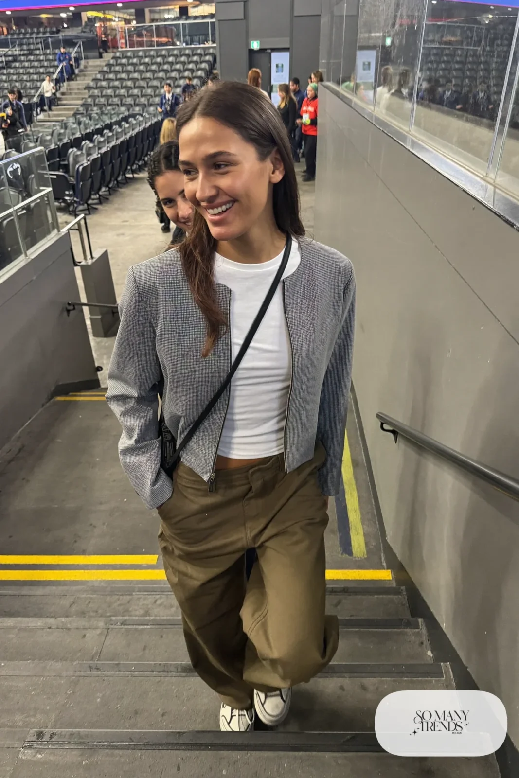 Woman in cropped gray wool jacket, white long-sleeve tee, olive wide-leg cargo pants and chunky sneakers, hockey game outfit 16