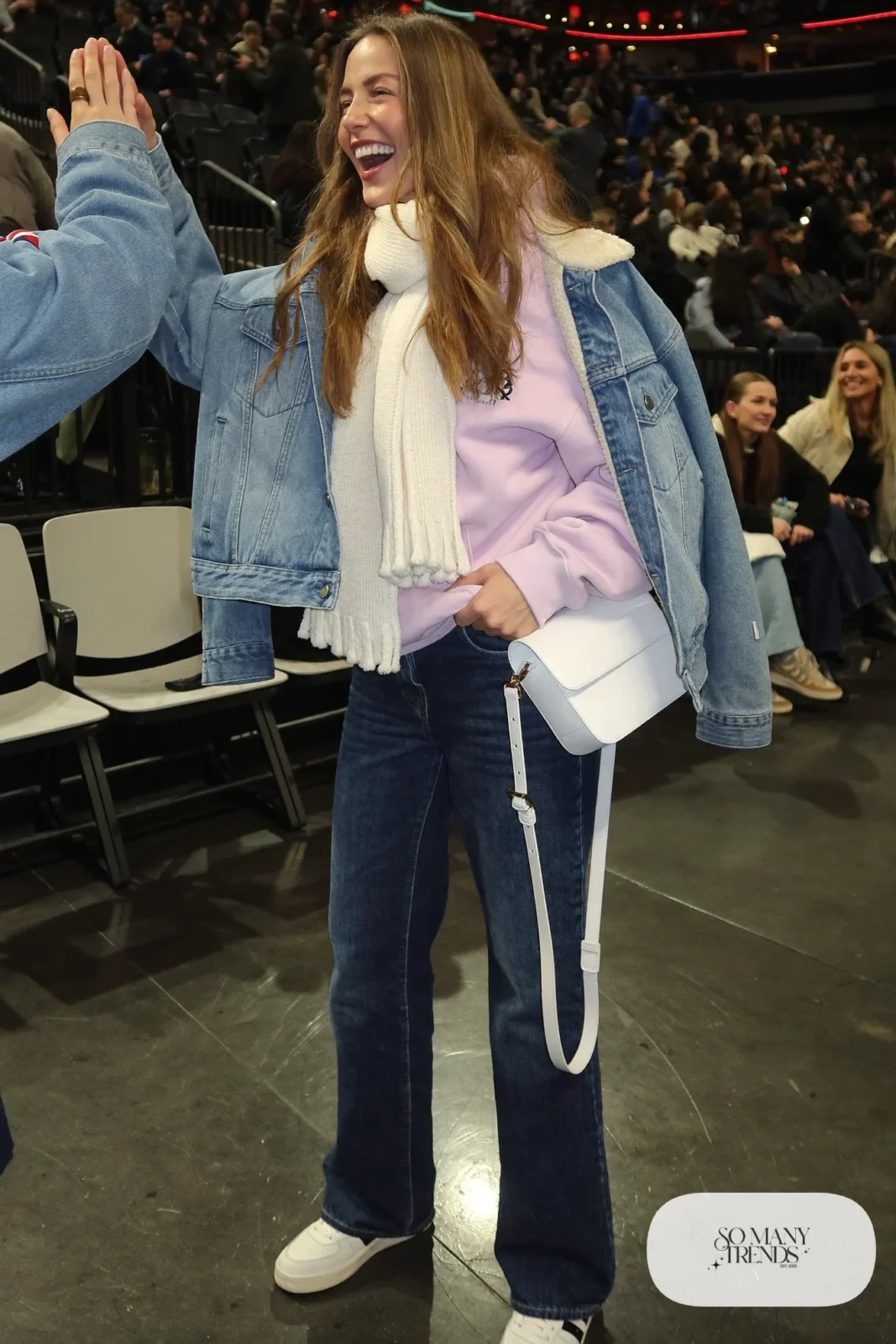 Woman in sherpa-lined denim jacket, pink hoodie, dark straight jeans, white sneakers and knit scarf, hockey game outfit 28