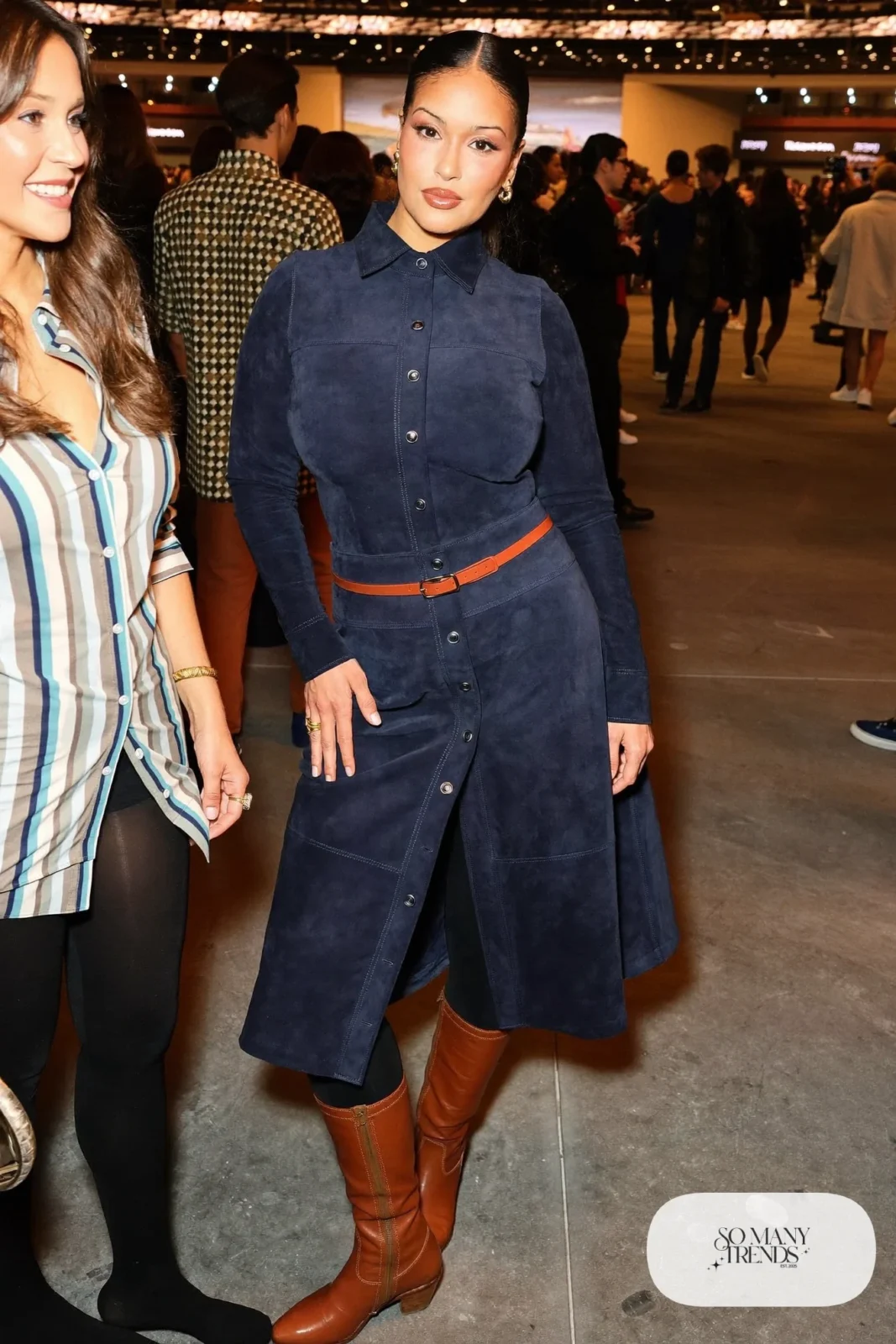 Woman in a matching navy suede-look button skirt and top set with tall cognac boots, concert outfit 13