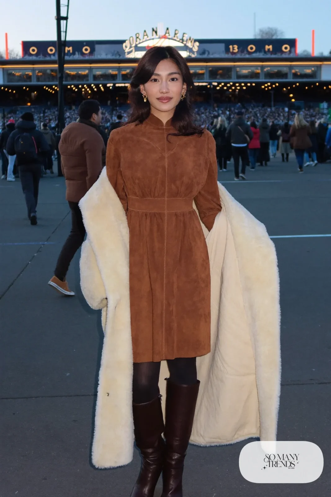 Woman in a cognac suede-look midi dress, white shearling coat and tall brown boots, concert outfit 22