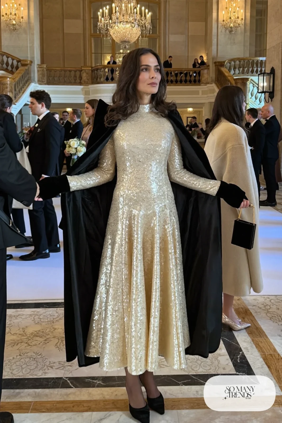 champagne sequin long-sleeve flared midi dress, black velvet long coat, black closed-toe pumps, sheer tights, small black bag, winter wedding guest outfit 13
