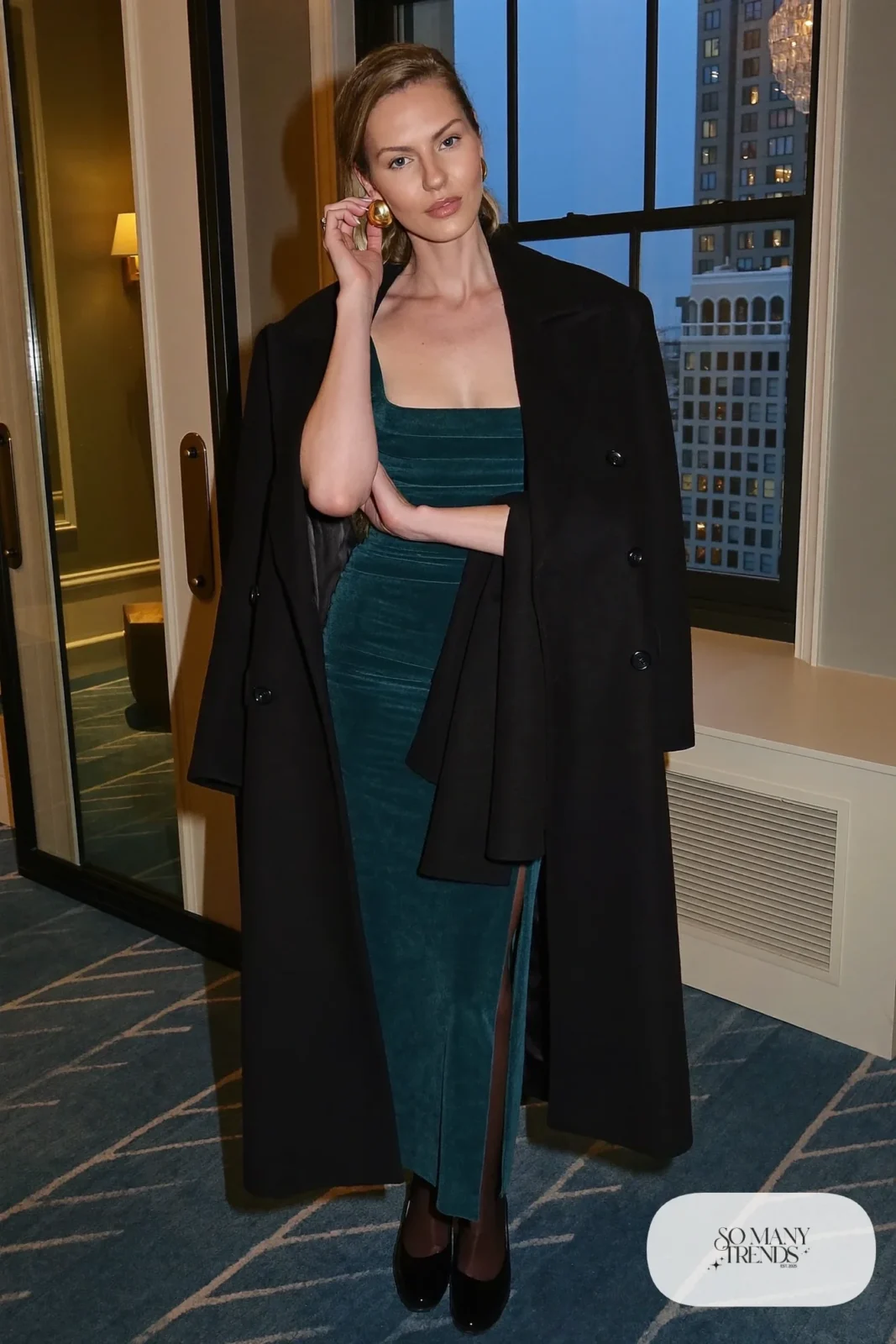 dark teal crepe long-sleeve column gown, large gold earrings, black closed-toe pumps, sheer tights, long coat, winter wedding guest outfit 18