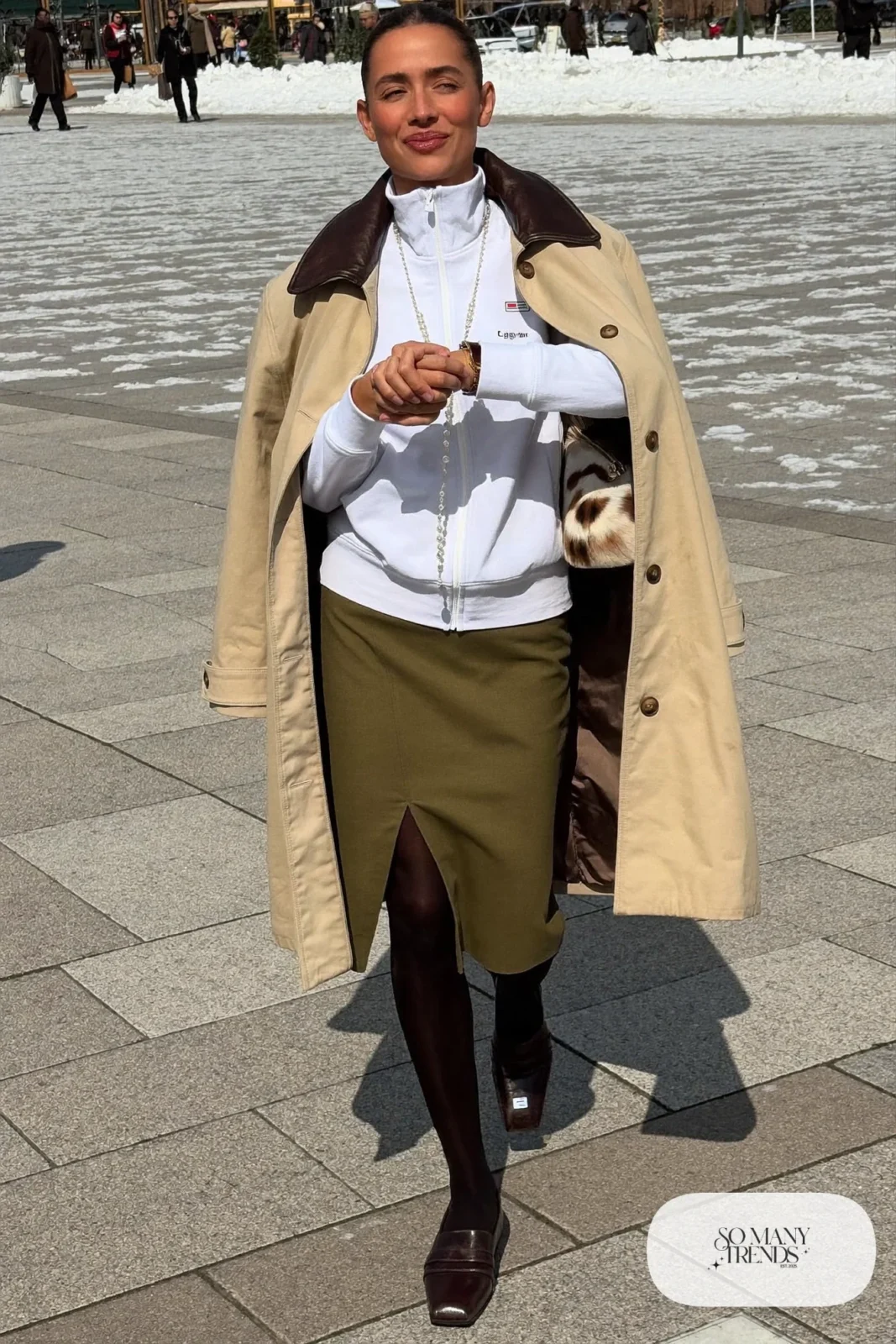 Look 12: white zip funnel-neck track jacket, olive midi skirt with front slit, beige car coat with brown collar, dark brown loafers and a long pendant
